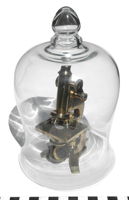 Glass dome over a brass microscope